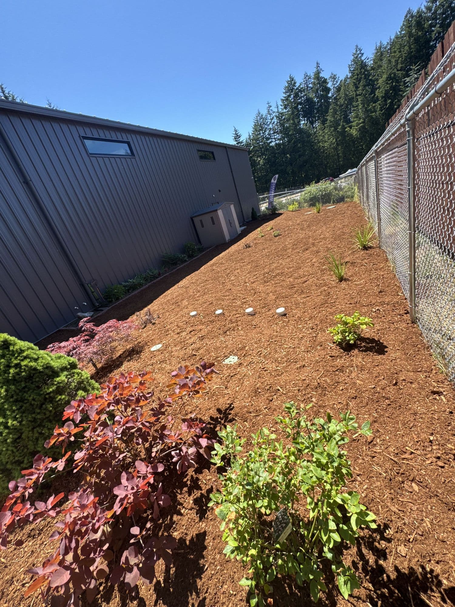 Bark mulch bed installation along a fence line